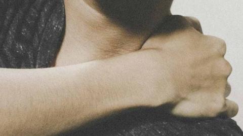 person holding their shoulder at the neck