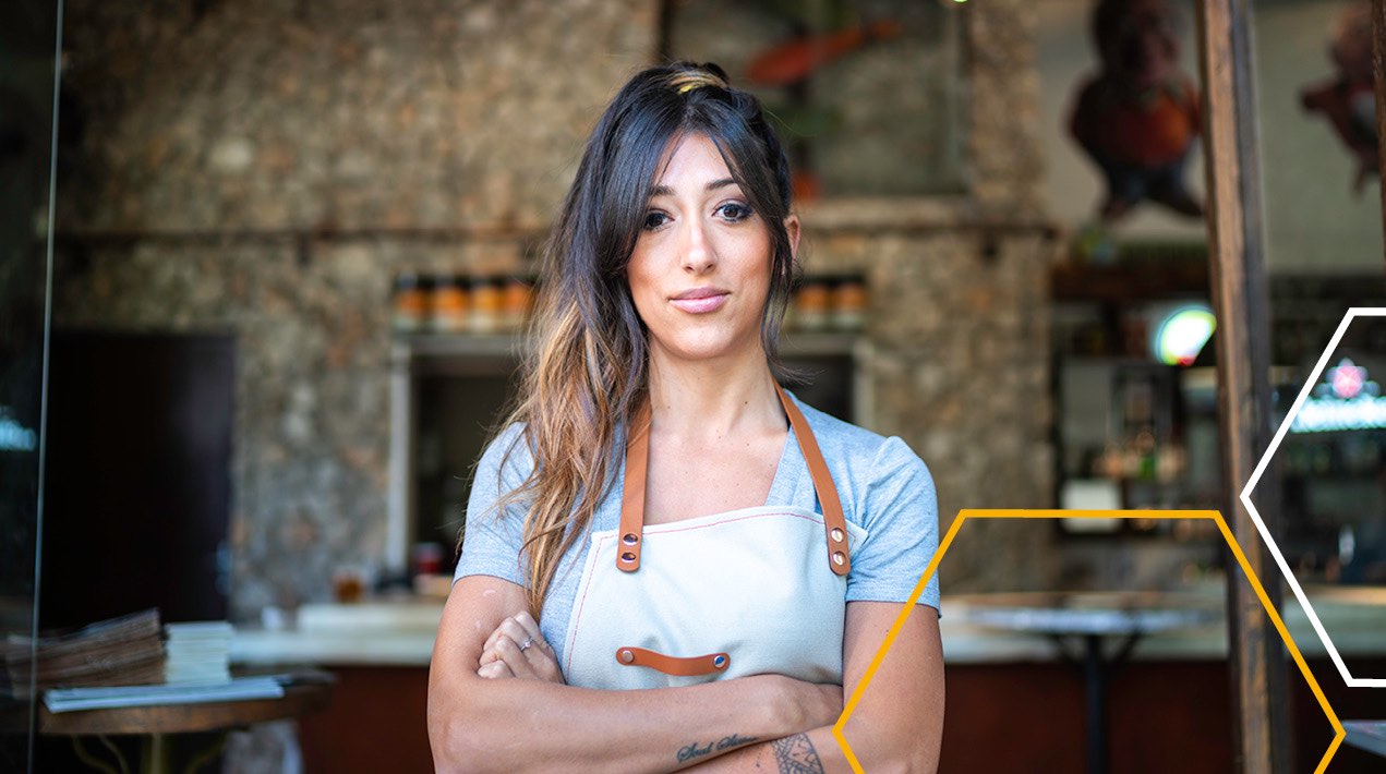 Restaurant worker in front of a stone pizza oven